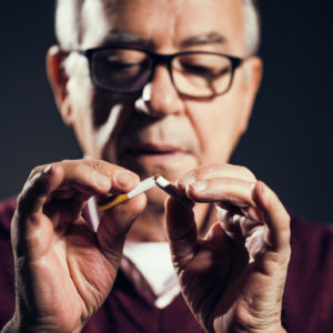 Close up image of senior man who is decided to quit smoking.